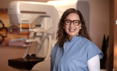 Mammography Technologist, Deborah Culbertson stands in front of a Fuji 3D Mammography machine, installed December 2024.Picture of mammography technologist standing next to Fuji 3D Mammography machine.