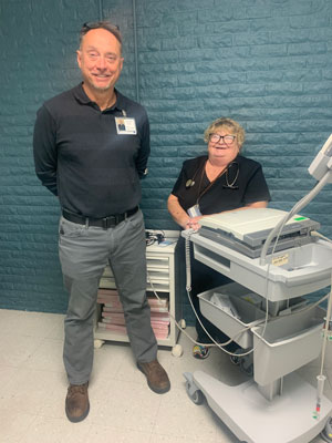 Pictured is two of our staff members next to a machine.