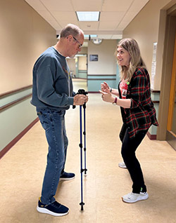 Physical Therapy Assistant, Melenna Tabakian guides patient, Glenn Gilmore, with PWR!Moves exercises.Photo of therapist working with patient.